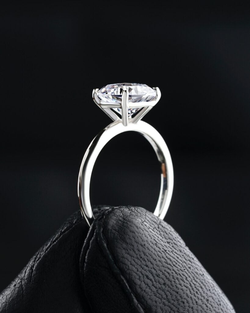 Side-view anatomy of an engagement ring showing profile height, basket, gallery, prongs, and shank