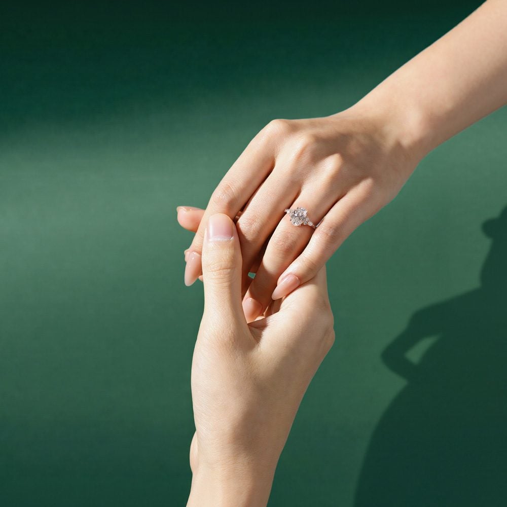 A man was holding the hand of a woman, and the woman was wearing an engagement ring on her hand.