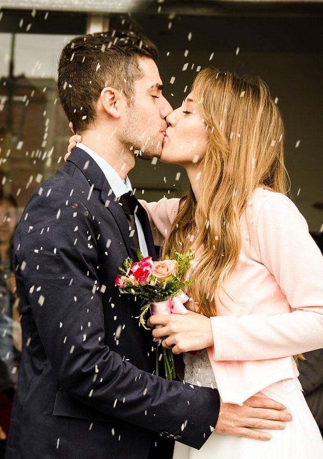 The couple wearing wedding rings are kissing each other. The couple wearing wedding rings are kissing each other.